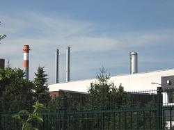 Fabrik mit Schornsteinen, die Immissionen an die Luft abgeben
