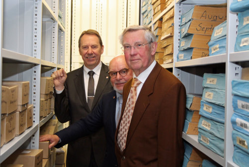 Die Sammlung zur oberbergischen Leichtathletik-Geschichte ist ins Kreisarchiv eingezogen. Landrat Jochen Hagt (l.), Kreisarchivar Gerhard Pomykaj (M.) und Rolf Fiedler (r.) haben die Kartons eingelagert. (Foto: OBK) 