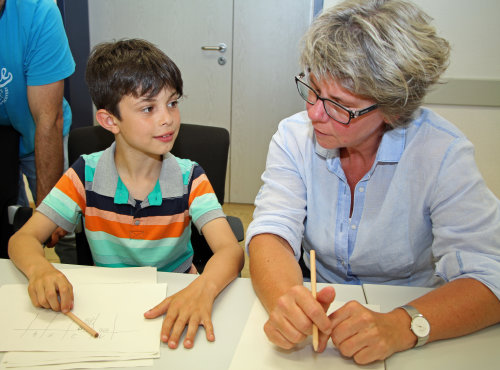 Stefano Sicari, zeigt seiner Schulleiterin Sabine Kremer (GGS Engelskirchen) wie er die Matheaufgaben gelöst hat - auf jedem Fall mit Spaß am Rechnen. (Foto: OBK)