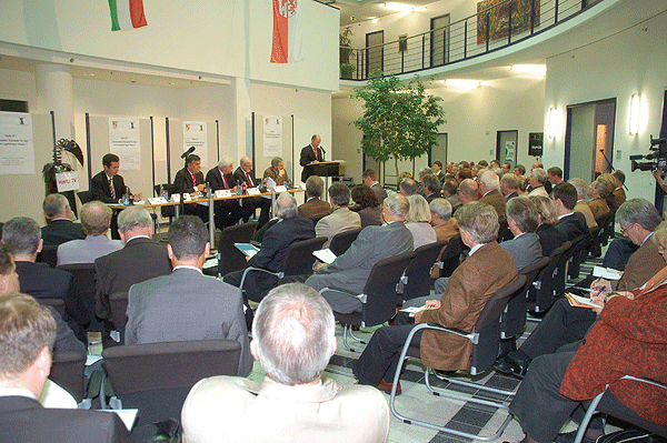 Das Foto zeigt im Vordergrund die Zuhörer während der Diskussionsrunde im Kreishaus und im Hintergrund das Podium