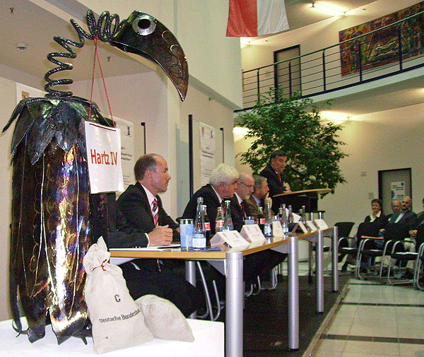 Das Foto zeigt das Podium während der Diskussionsrunde im Gummersbacher Kreishaus am 16.10.2006 mit dem Pleitegeier "Peter" im Vordergrund
