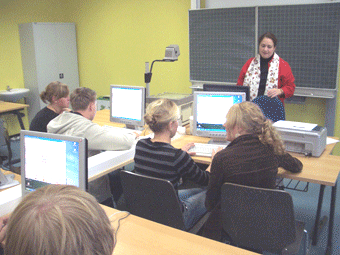 Das Bild zeigt SchülerInnen der Realschule Lindlar am PC mit unterrichtender Lehrerin.