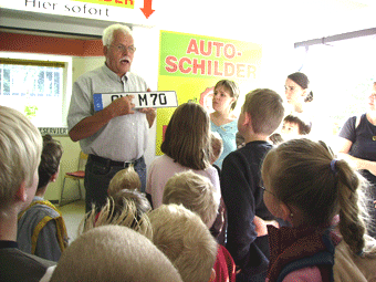 Rolf Medgenberg vom Straßenverkehrsamt erklärt den Kindern die Nummernschilder