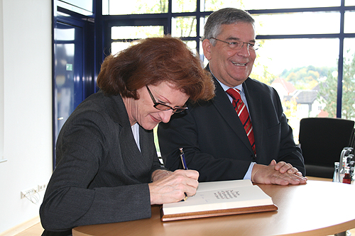 Regierungspräsidentin Gisela Walsken trägt sich ins "Goldene Buch" des Kreises ein. (Foto: OBK) 