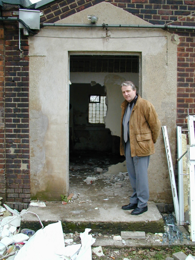 Kreisdirektor Norbert Wolter vor einem zerstörten Haus