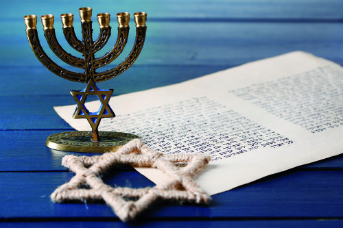 Symbole jüdischen Glaubens: der siebenarmige Leuchter - Menora - mit Davidstern und ein Text in hebräischer Schrift.
(Foto: AdobeStock_69495273_Africa Studio)