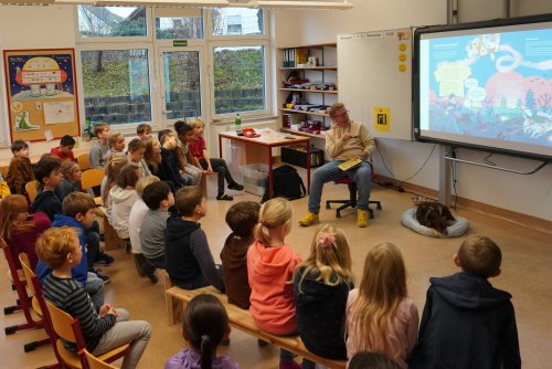Kinderbuchautor Henrick Clausing las mit seinem Hund Filou in der Grundschule Lindlar-West aus seinem aktuellen Buch „Auf diese Pfoten ist Verlass“. (Foto: OBK)