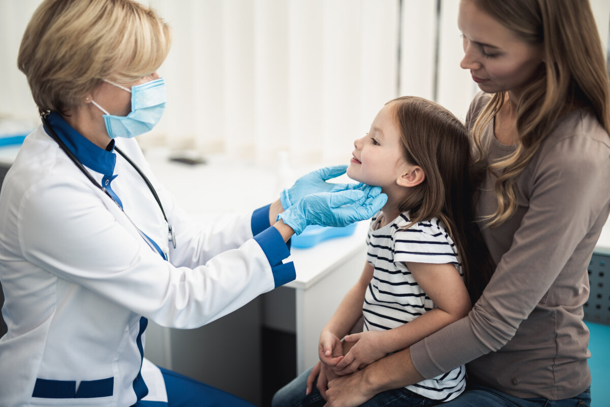 Consultation of female kid with mother by doctor