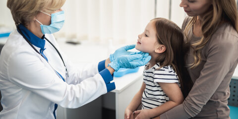 Consultation of female kid with mother by doctor