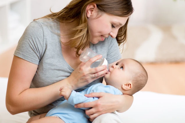 young mother feeding her adorable baby