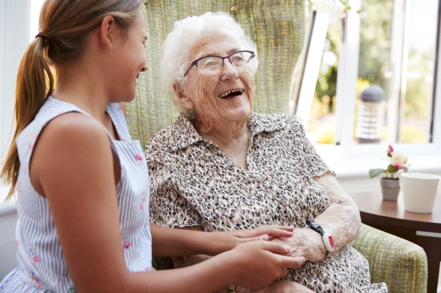 Granddaughter Visiting Grandmother In Lounge Of Retirement Home