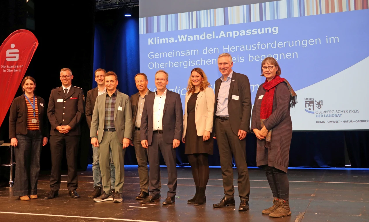 Einblicke in die laufenden Projekte vermittelte die Abschlussveranstaltung des KWAK in der Halle 32 (v. l.): Christiane Weitkemper, Projektagentur Oberberg GmbH; Kreisbrandmeister Julian Seeger, Leiter des Amtes für Brand-,Zivil- und Katastrophenschutz; Thomas Groos, KUNO; ARD-Meteorologe Donald Bäcker; Frank Herhaus, Kreisdezernent Planung, Regionalentwicklung, Umwelt; Landrat Klaus Grootens; Julia Wäger, Projektagentur Oberberg GmbH; Dr. Uwe Moshage, Aggerverband und Christine Wosnitza, Biologische Station Oberberg. (Foto: OBK)      